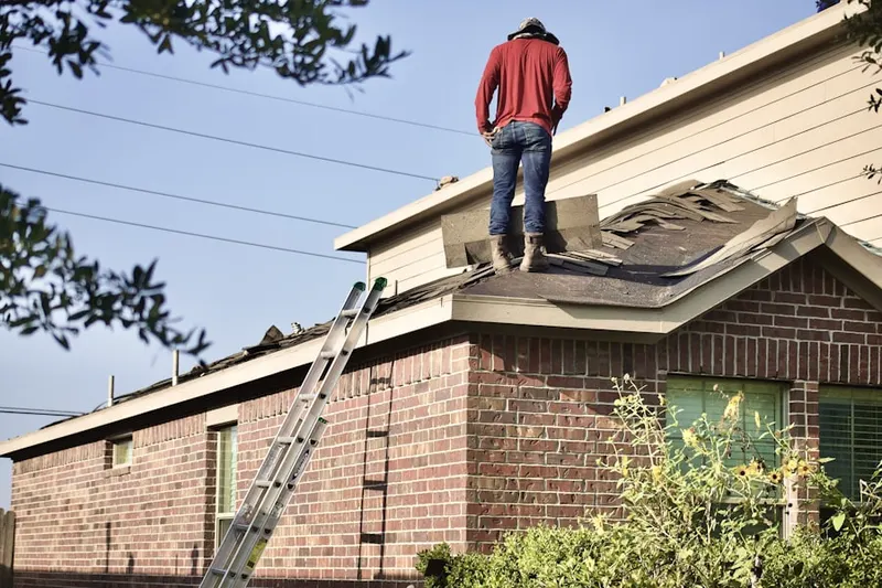 Professional roofer working on a residential roof in Rock Manor